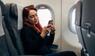 Frau im Flugzeug am Handy