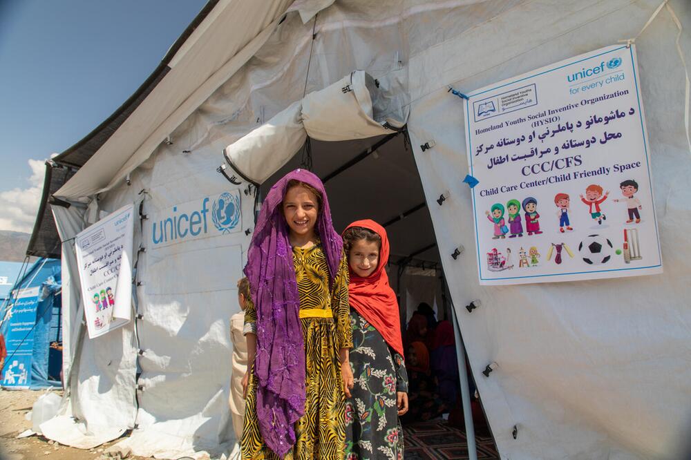 Zwei Mädchen vor einem weißen Zelt in einem Camp in Afghanistan.
