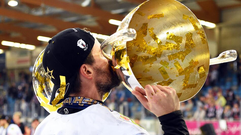 Berlins Morgan Ellis küsst nach dem Gewinn der zehnten deutschen Eishockey-Meisterschaft den Pokal.