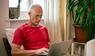 Mann schaut auf einen Laptop