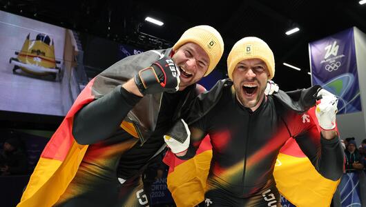 Johannes Lochner und Anschieber Georg Fleischhauer feiern ihren Olympiasieg.