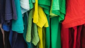 Nahaufnahme von hängenden T-Shirts in verschiedenen Farben, darunter Blau, Türkis, Hellblau ...