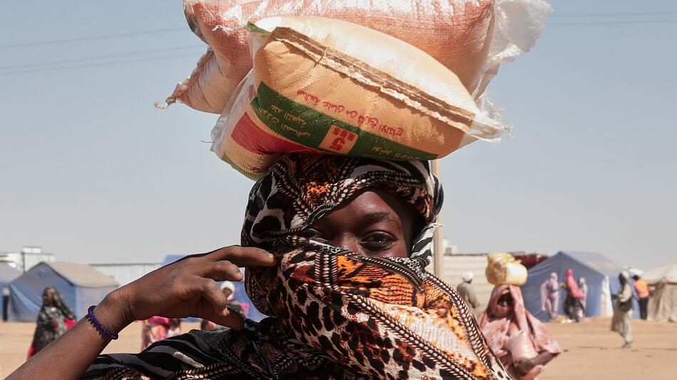 Eine Frau trägt Säcke auf dem Kopf