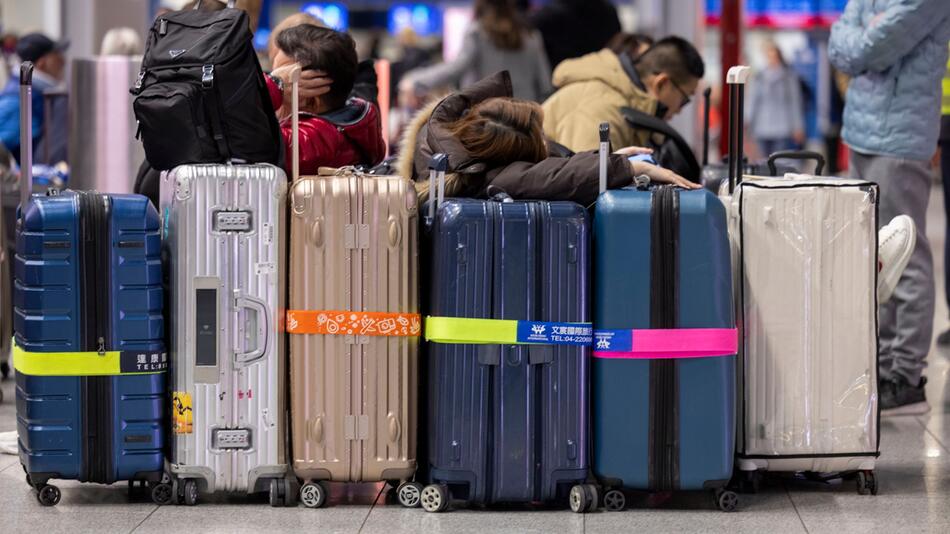 Reisende warten in der Abflughalle eines Flughafen