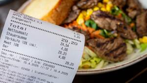 Eine Rechnung mit Mehrwertsteuer neben einem vollen Teller in einem Restaurant. 