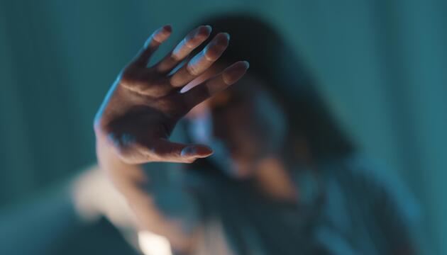 Frau streckt ihre Hand als Zeichen für "Stop" nach vorne