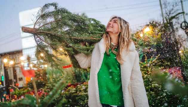 Frau kauft Weihnachtsbaum