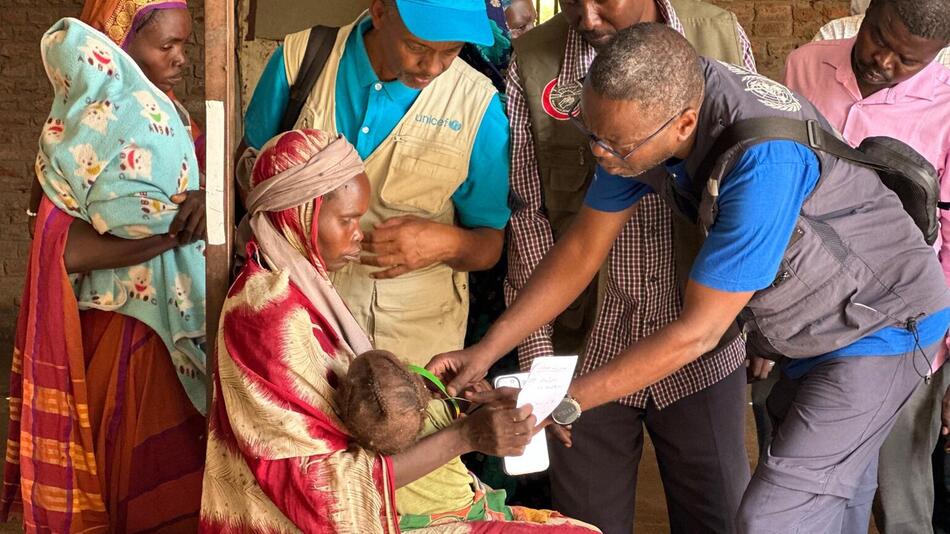 UNICEF Mitarbeiter kümmern sich um ein Kind und seine Mutter