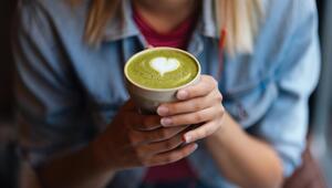 Frau hälte eine Tasse mit Matcha in den Händen