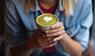 Frau hälte eine Tasse mit Matcha in den Händen