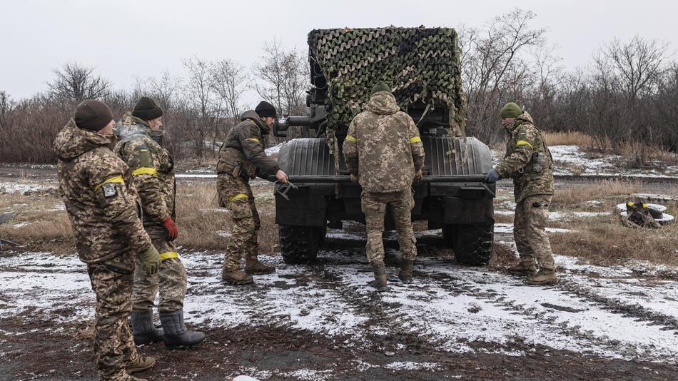 Ukrainische Soldaten laden Artilleriegeschütz