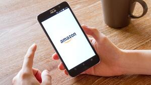 Ein Mensch hält ein Smartphone in der Hand, auf dem Bildschirm ist das Logo von Amazon zu sehen.
