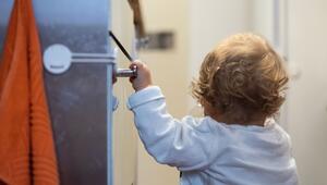 Ein Kind hält sich an einem Schrank mit Sicherung fest