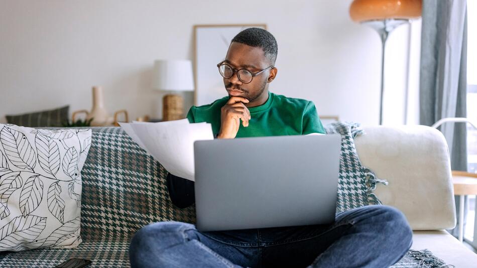 Mann sitzt am Laptop