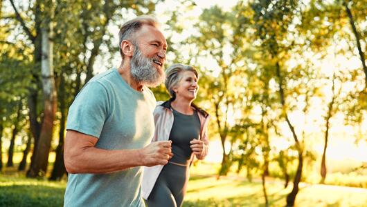 Älteres Paar joggt durch den Park
