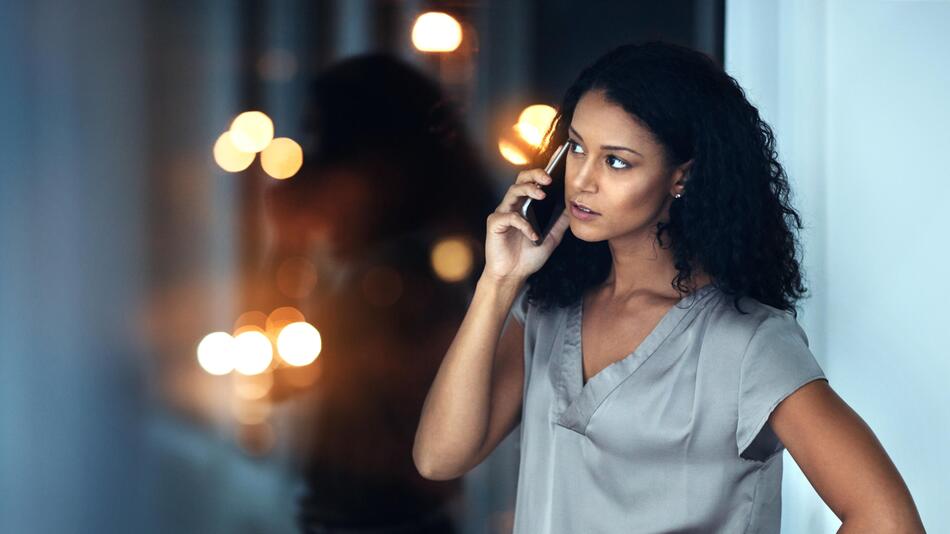 Junge Frau ist genervt am Telefon