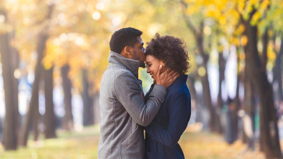Mann küsst Frau auf die Stirn