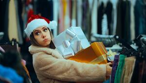 Genervte Frau hält Stapel mit Geschenken 