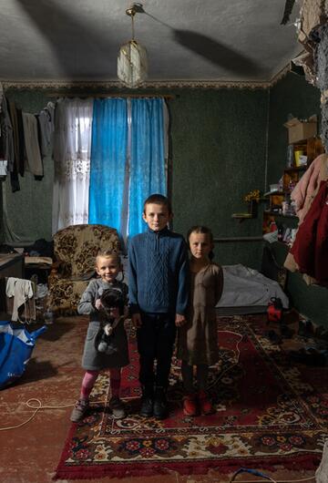 Geschwister in einem zerstörten Haus in der Ukraine