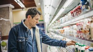 Mann in Supermarkt, der Preise vergleicht. 
