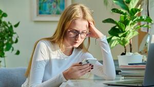 Frau schaut skeptisch auf ihr Handy