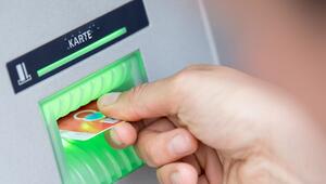 Person steckt Girokarte in einen Geldautomaten