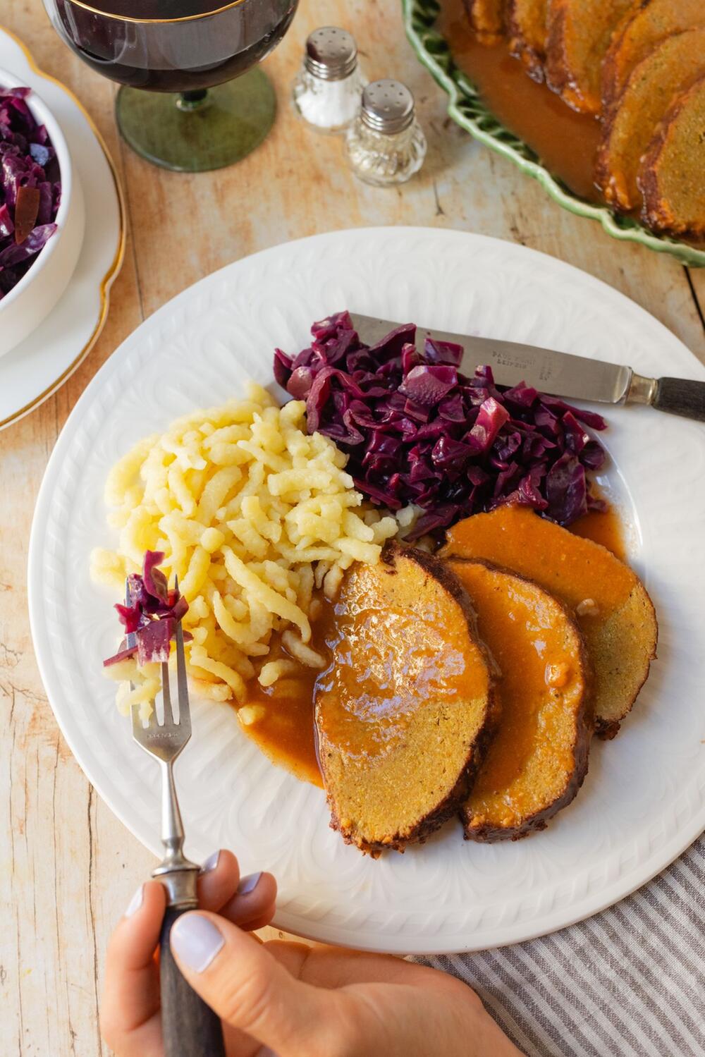 Sauerbraten, Spätze und Rotkohl angerichtet auf einem Teller