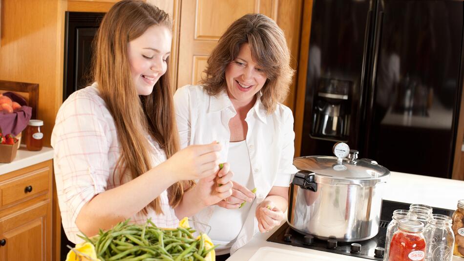 Zwei Frauen kochen mit Schnellkochtopf und sparen damit Energie