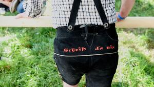Ein Mann hat "Scheiß da nix" auf seine Lederhose gestickt