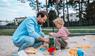 Vater spielt mit Kind im Sandkasten