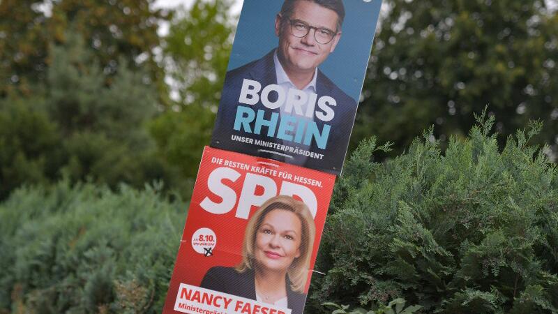 Wahlkampfplakate der CDU und SPD hängen in Hessen an einer Laterne.
