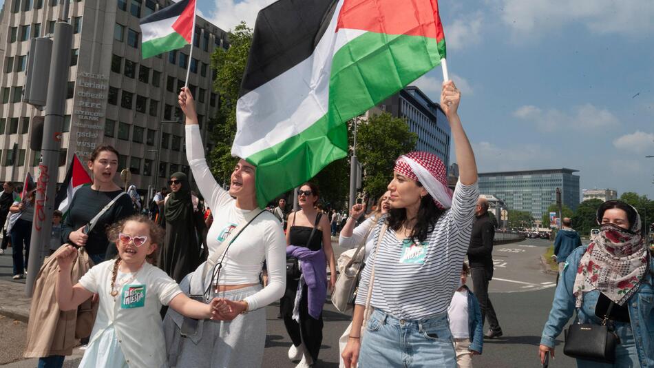 Frauen bei einer Demonstration halten die Flagge von Palästina in die Luft