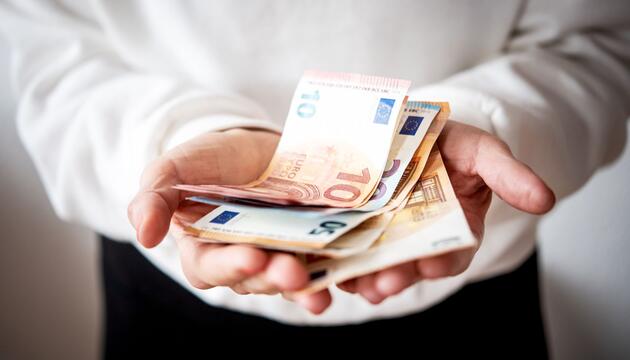 Eine Frau hält Geldscheine in den Händen