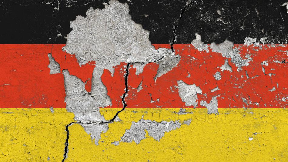 Bröckelnde Mauer in Deutschlandfarben.