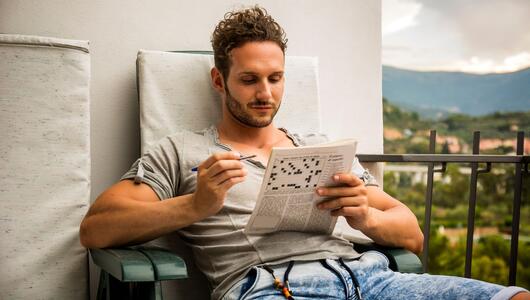 Mann mit Kreuzworträtsel in der Hand