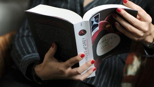Eine Frau liest im Buch "Shades of Grey"