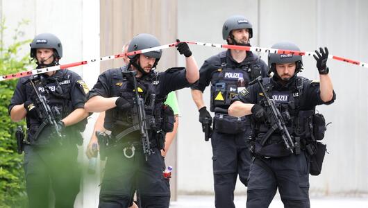 Schwerbewaffnete Polizisten stehen am Welfen-Gymnasium.
