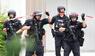 Schwerbewaffnete Polizisten stehen am Welfen-Gymnasium.
