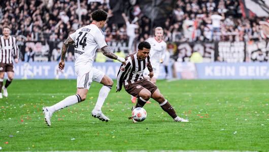 St. Pauli-Spieler Joel Chima Fujita verteidigt den Ball vor Frankfurts Nnamdi Collins.