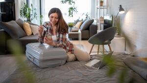 Frau, die Reiseunterkünfte online mit Kreditkarte und Smartphone bucht