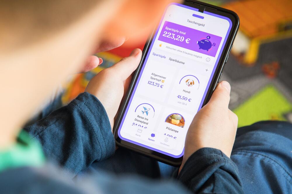 Junge schaut sich auf der Bling-App sein Sparguthaben an