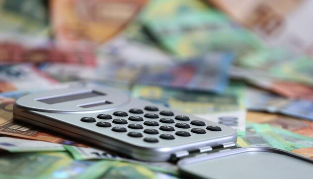 Ein Taschenrechner liegt auf verschiedenen Euro-Banknoten.