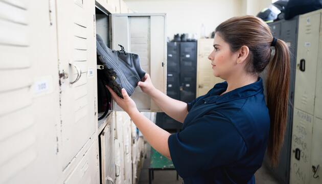 Frau zieht sich in der Umkleidekabine der Arbeit um