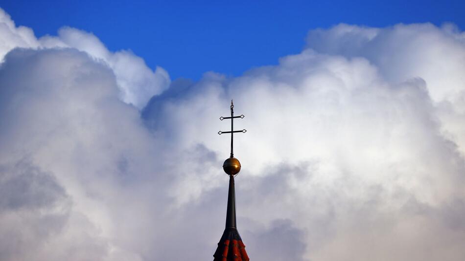 Wolken türmen sich über Kirchturm