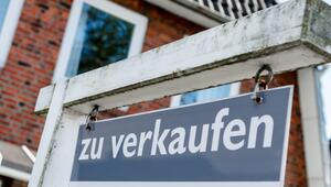 Ein Schild mit der Aufschrift "zu verkaufen" steht vor einem Haus