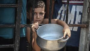 Foto eines Kindes mit leerem Topf in Gaza-Stadt, das auf Essen von Hilfsorganisationen wartet