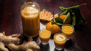 Eine Flasche und drei Gläser mit Ingwershot stehen auf dem Tisch