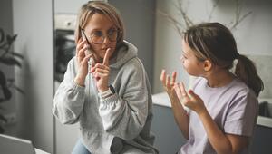 Foto einer Mutter im Homeoffice, die von Tochter gestört wird