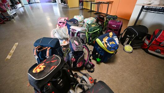 Schulranzen vor einem Klassenzimmer einer Grundschule.