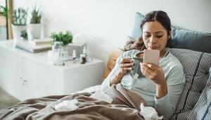 Kranke Frau im Bett mit Handy